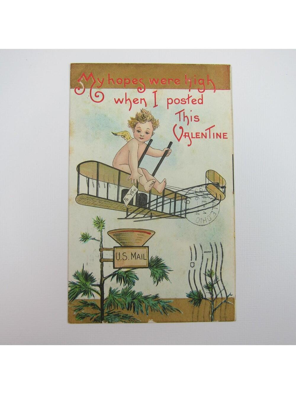 Postcard  Valentine Cupid Rides Biplane Airplane Over Mailbox Tree Antique 1911